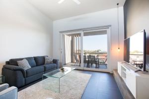a living room with a couch and a glass table at Magnificent Apartment + FREE car park near CBD in Adelaide