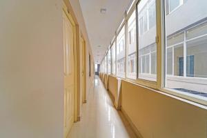 an empty hallway with windows in a building at Townhouse Kozhencherry Formerly The Beige Hotel in Pathanāmthitta