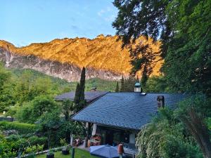 a house with a roof with a mountain in the background at By Wallner's in Sankt Leonhard
