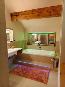 a bathroom with a tub and a sink and a mirror at By Wallner's in Sankt Leonhard