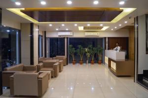 a lobby of a hotel with a man standing at a counter at Hotel Midtown in Vadodara