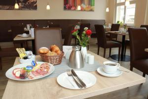 a table with two plates of food and a cup of coffee at Hotel Vita Berlin-Messe in Berlin