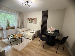 a living room with a table and a couch at Vespera Apartment - Retkinia in Łódź