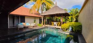 a swimming pool with a gazebo next to a house at Villa 24 in Grand-Baie