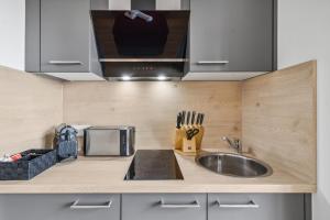 a kitchen counter with a sink and a microwave at Hotel Suite4Me Dietzenbach in Dietzenbach +5 photos