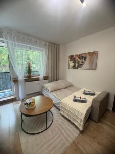 a living room with two beds and a table at Vespera Apartment - Retkinia in Łódź