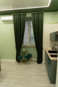 a kitchen with green curtains and a table and chairs at Na Suite QuartieriSpagnoli in Naples +28 photos
