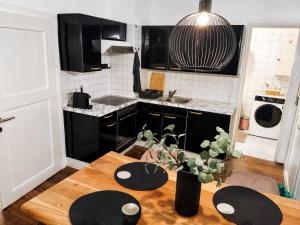 a kitchen with a wooden table and black cabinets at Faraway Homes Studio Enns #14 in Enns