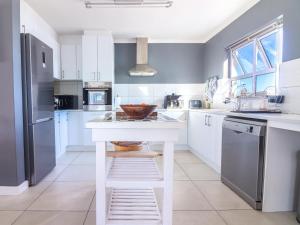 a kitchen with a white island with a bowl on it at Bluemist Accommodation in Gansbaai