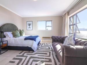 a bedroom with a bed and a couch at Bluemist Accommodation in Gansbaai