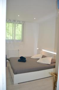 a white bedroom with a bed with a window at Sun beach in Tresserves