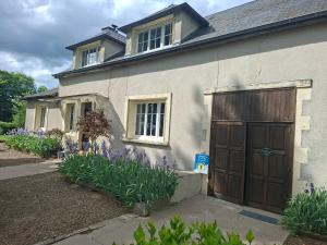 a house with a brown door and purple flowers at C'est Si Bon in Vandenesse