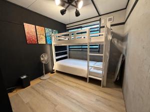 a bedroom with a bunk bed and a fan at しばママのお宿 ShibaMamas Casual Hotel in Zaō Onsen