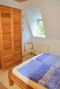 a bedroom with a bed and a wooden closet at Zaumseil, Axel Fe-App "oben" in Schönberg