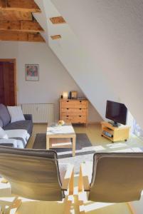a living room with a couch and a tv at Zaumseil, Axel Fe-App "oben" in Schönberg +16 photos