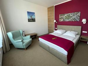 a hotel room with a bed and a chair at Hotel Vita Berlin-Messe in Berlin