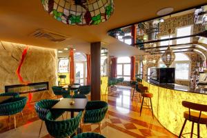 ein Restaurant mit grünen Stühlen und Tischen und einer Bar in der Unterkunft Hotel Guardamar in Guardamar del Segura