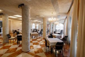 ein Restaurant mit Tischen und Stühlen und einem Kronleuchter in der Unterkunft Hotel Guardamar in Guardamar del Segura