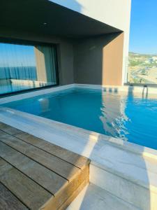 a swimming pool with a view of a building at Cavo Drymades in Dhërmi