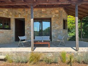 a stone house with two chairs and a table at The Hill House in Argalasti +11 photos