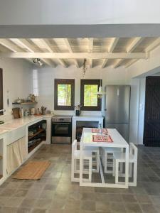a kitchen with a white table and chairs in it at The Hill House in Argalasti