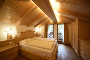 a bedroom with a large bed in a room with wooden ceilings at Romantic Chalet Dolomiti in Val di Zoldo