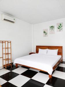 a bedroom with a bed with a black and white checkered floor at Bungalow Gió Hát in Phú Quốc