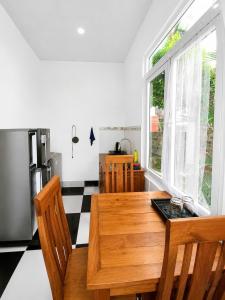 a kitchen with a wooden table and a refrigerator at Bungalow Gió Hát in Phú Quốc