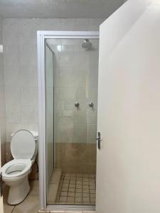 a bathroom with a glass shower with a toilet at Margate Boulevard - Seaview Apartment in Margate