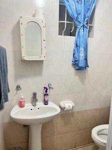 a bathroom with a sink and a mirror and a toilet at Margate Boulevard - Seaview Apartment in Margate