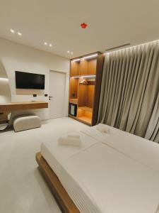 a bedroom with a bed and a flat screen tv at Cavo Drymades in Dhërmi