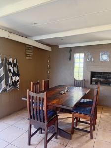 a dining room with a wooden table and chairs at Beach Cottage Abigail in Southbroom