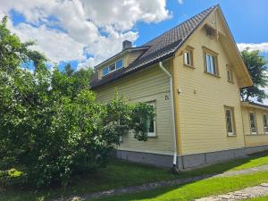 a yellow house with a gambrel roof at Papli Villade Apartment in Pärnu