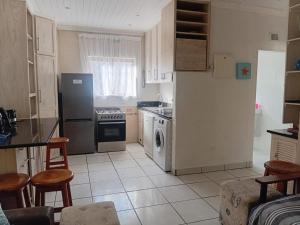 a kitchen with a refrigerator and a dishwasher at Beach Cottage Abigail in Southbroom +10 photos