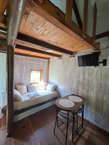 a room with a bed and a table and a tv at camping los pradones in Cudillero