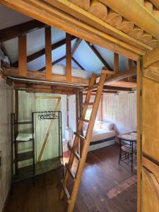 an attic room with a bunk bed and a ladder at camping los pradones in Cudillero