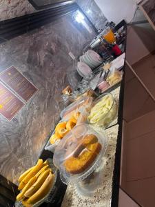 a counter top with bananas and other food on it at Hospedaria Monumento in São Paulo