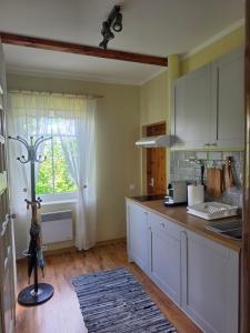 a kitchen with white cabinets and a window at Papli Villade Apartment in Pärnu
