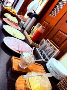 a counter topped with plates and bowls of food at Pousada Center in Barreirinhas