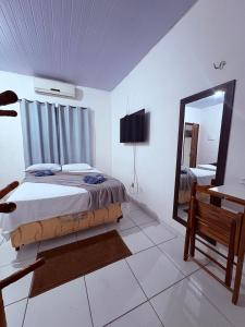 a bedroom with a bed and a large mirror at Pousada Center in Barreirinhas