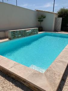 a swimming pool with blue water in front of a house at Chambre 2 piscine in Gignac +1 photo