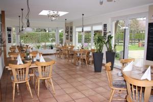 a restaurant with wooden tables and chairs and windows at Gasthaus Zum Rethberg in Lübstorf
