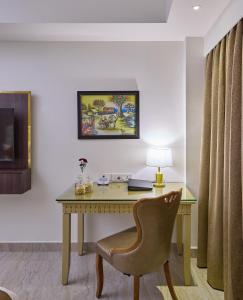 a desk in a room with a chair and a lamp at Grand Continent Premiere - T Nagar in Chennai