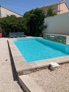 a swimming pool with blue water in a yard at Chambre 2 piscine in Gignac
