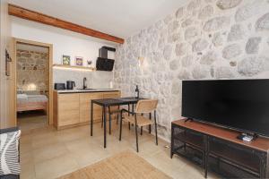 a living room with a television and a table with chairs at Historic Waterfront Apartment in Muo