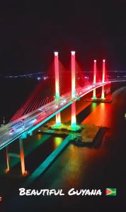 a bridge lit up at night with red and green lights at #1 Diamond Hotel and Residences in Georgetown