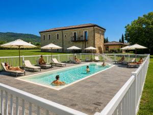 a group of people sitting in a swimming pool at Podere Meroli in Scorcetoli