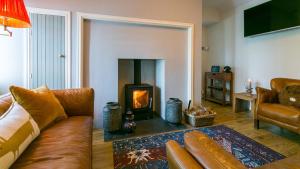 a living room with a couch and a fireplace at Penrallt in Benllech
