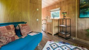 a living room with a blue couch in a tiny house at Penrallt in Benllech
