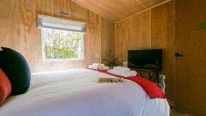 a bedroom with a large white bed with a window at Penrallt in Benllech